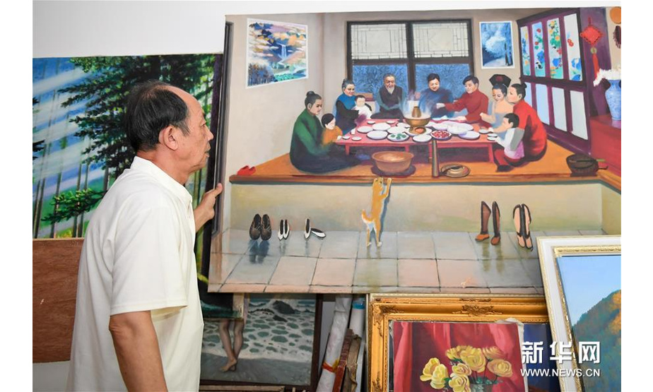 7月18日，吴吉人在家中整理自己的画作。新华社发（颜麟蕴摄）