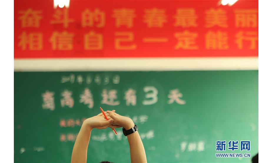 6月4日，在湖南省衡阳县第一中学，一名高三学生自习间隙伸腰活动。 2019年全国高考临近，高三学生认真复习备考。 新华社发（曹正平摄）