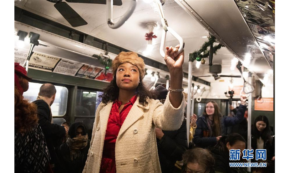 12月8日，在美国纽约，人们搭乘“怀旧专列”。 每年感恩节到新年之间的星期日，纽约地铁都会用1932年至1977年间使用的老式列车在运营的线路上开行特别的“怀旧专列”，人们穿戴旧时服饰专程前来搭乘，体验时光回溯的奇妙旅程。 新华社记者 王迎 摄