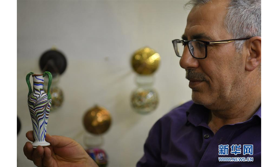 5月27日，在叙利亚大马士革，工匠穆罕默德·哈拉克展示手工玻璃制品。 新华社发（阿马尔摄）