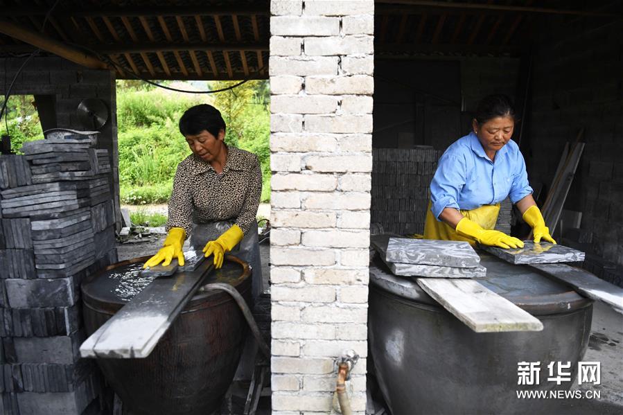8月15日，在泾县茂林花砖厂，工人在水磨烧制出来的花砖。 花砖是安徽省泾县茂林镇特有的一种古建装饰材料，主要用于门、墙、窗户的装饰。上品花砖呈青白色，不仅花纹清晰、图案雅致，而且具有手感轻柔、不沾灰的特点。明清时期，花砖开始普遍运用于茂林当地民宅中。然而，花砖制作工艺复杂，成本高，加上花砖艺人因躲避战乱流落他乡，花砖制作工艺一度失传。20世纪90年代，茂林人开始重新挖掘花砖制作工艺，逐渐恢复了花砖的生产。如今，花砖制作工艺包括取土、制坯、烧制、水磨等12道大的工序。2014年，花砖制作技艺被列为安徽省省级非物质文化遗产。 新华社记者 刘军喜 摄