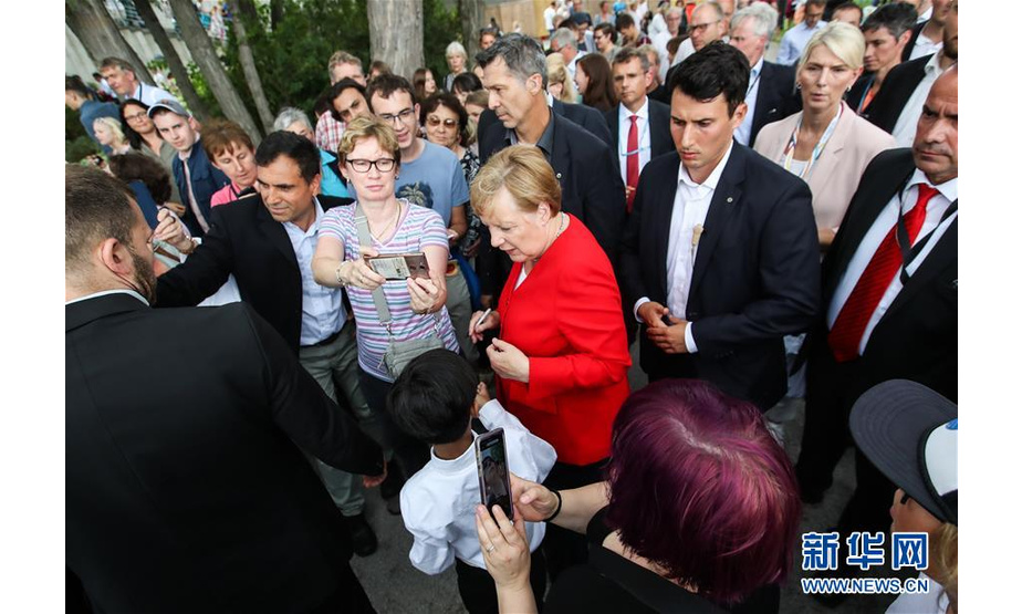 8月18日，在德国首都柏林，德国总理默克尔（中）参加开放日活动。新华社记者 单宇琦 摄