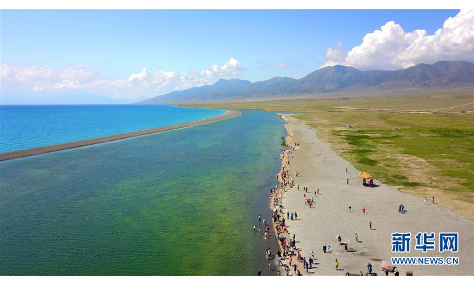 7月18日，游客在新疆赛里木湖观光游览（无人机拍摄）。  新华社发（许丛军 摄）