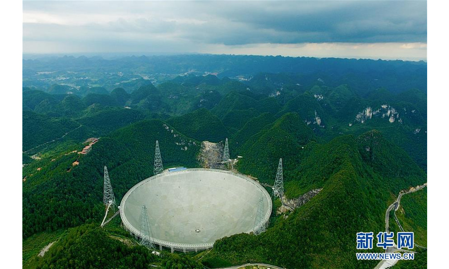 这是航拍的500米口径球面射电望远镜（FAST）全景（2017年8月9日摄）。自2016年9月25日落成启用以来，500米口径球面射电望远镜——“中国天眼”共发现51颗脉冲星候选体，其中有11颗已被确认为新脉冲星。新华社记者 欧东衢 摄