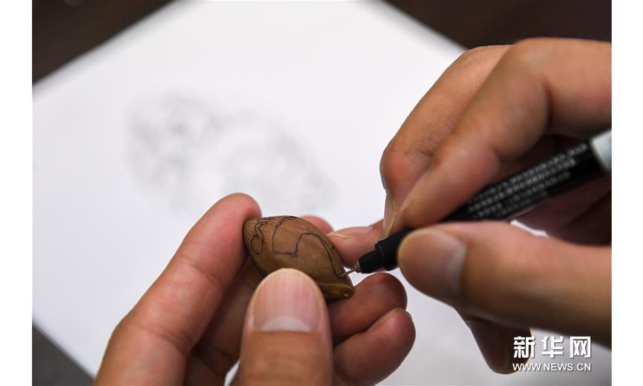 9月18日，马罗成在核艺工作室里雕刻初胚。 36岁的马罗成是长沙市天心区非物质文化遗产“罗成核雕”代表性传承人。他21岁入行，师从国家级非物质文化遗产光福核雕传承人周建明，从事核雕十多年来，马罗成通过不断学习、模仿和创新，逐渐形成自己特有的风格。每一件核雕作品从原料选取、工具选用到雕刻过程，马罗成都一丝不苟，其核雕作品深受消费者喜爱。 马罗成一手传承，一手创新。2012年开办罗成核艺工作室，他除了带徒弟，还着手“罗成核雕”的文创产品开发，希望能够“以产养遗”，将这门非遗技艺不断传承下去，让核雕的魅力被更多人所熟知。 新华社记者 陈泽国 摄