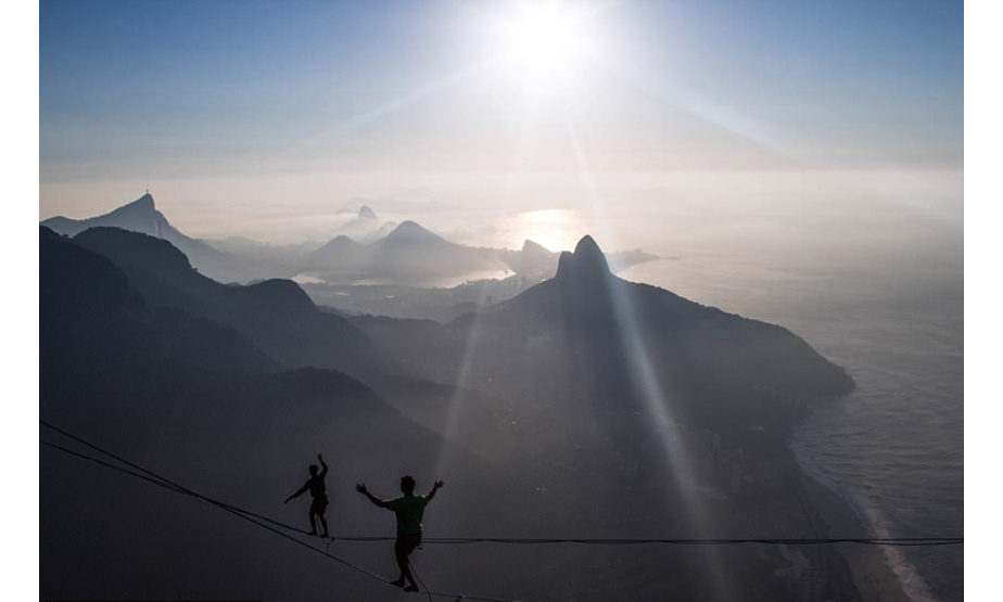巴西一名摄影师在里约和朋友登山时，无意间拍到了几名高空走绳者在山崖间悬空绳索上行走的照片，照片中太阳升起的朝晖和走绳者的身影交相辉映，构成了一幅唯美壮丽的大好河山图。