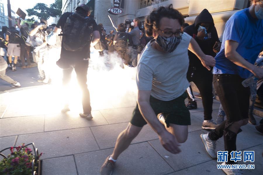 5月31日，在美国首都华盛顿，抗议者躲避警察发射的震爆弹。 由美国明尼苏达州白人警察执法致非洲裔男子死亡事件引发的抗议和骚乱5月31日仍在美国多地持续。31日，美国首都华盛顿民众走上街头抗议警察暴力执法和种族主义。 新华社记者 刘杰 摄