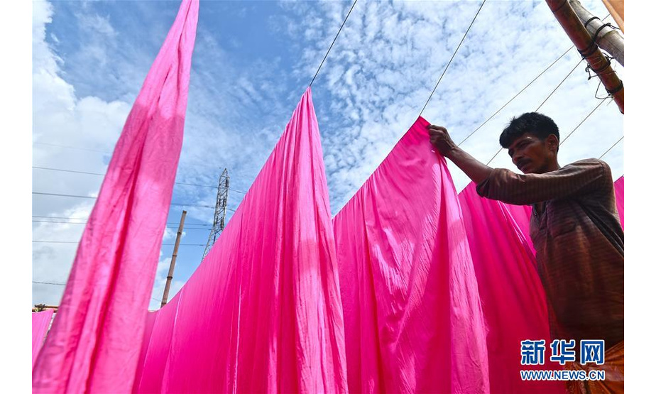 9月15日，在孟加拉国纳拉扬甘杰地区，当地村民将手工印染后的布匹进行晾晒。 在孟加拉国中部的纳拉扬甘杰地区，当地村庄还保留着手工印染的工艺。 新华社发（萨利姆摄）