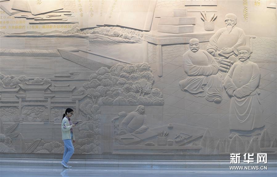 10月13日，读者从贵州省遵义市播州区图书馆内的浮雕墙前走过。新华社记者 杨楹 摄