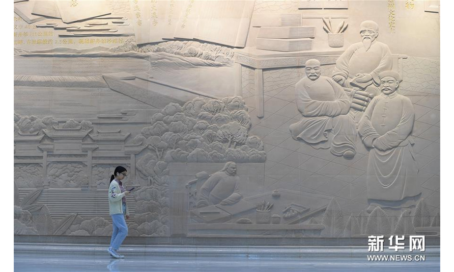 10月13日，读者从贵州省遵义市播州区图书馆内的浮雕墙前走过。新华社记者 杨楹 摄
