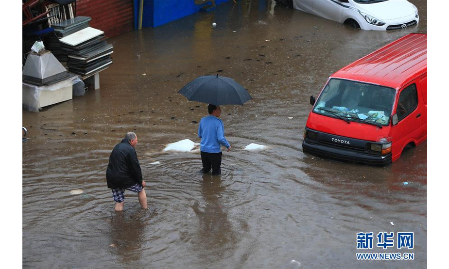 12月9日，在黎巴嫩首都贝鲁特，人们涉水出行。 黎巴嫩首都贝鲁特9日遭遇暴雨，导致部分道路被淹。 新华社发（比拉尔·贾维希摄）