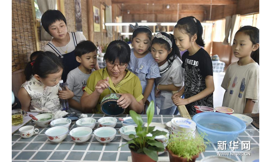 8月25日，孩子们在香河县北李庄村的乡村旅游非遗体验园里观摩景泰蓝制作技艺。 新华社记者 鲁鹏 摄