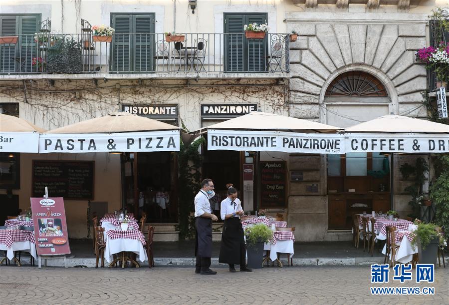 8月4日，在意大利首都罗马，一家餐厅的工作人员站在门口招揽顾客。 受新冠疫情影响，今年夏天罗马的历史中心区游客比往年明显减少。 新华社记者 程婷婷 摄