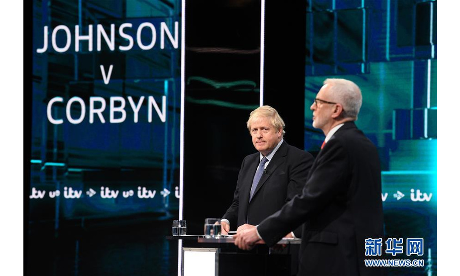 11月19日，在英国索尔福德，英国首相、保守党领袖鲍里斯·约翰逊（左）与英国工党领袖科尔宾参加英国独立电视台举办的首场电视辩论。新华社发（英国独立电视台供图）