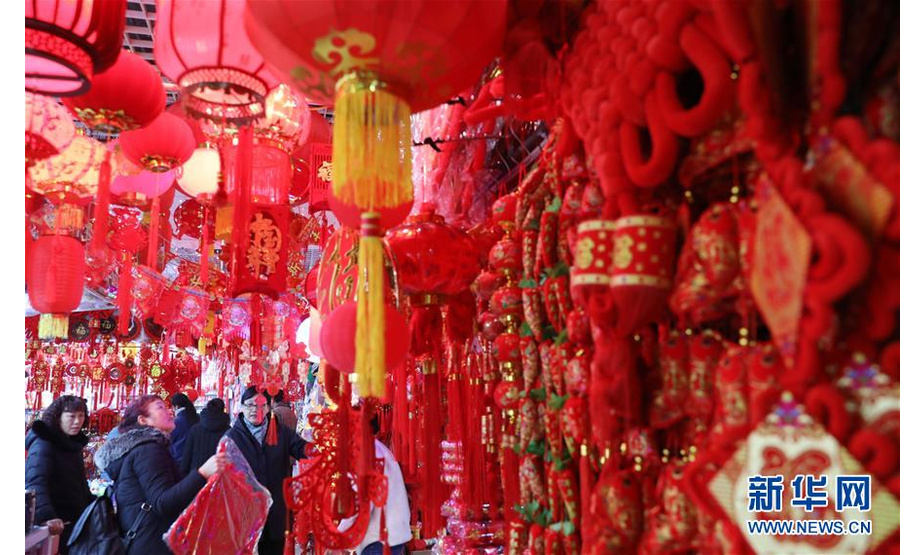 1月12日，市民在安徽省淮北市久兴年货市场上选购对联、灯笼、中国结等饰品。新华社发（李鑫 摄）

