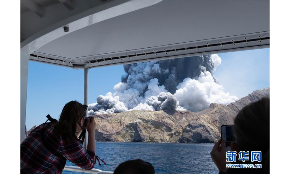 12月9日，一名游客在船上拍摄新西兰怀特岛火山喷发的情景。新华社发（迈克尔·谢德供图）
