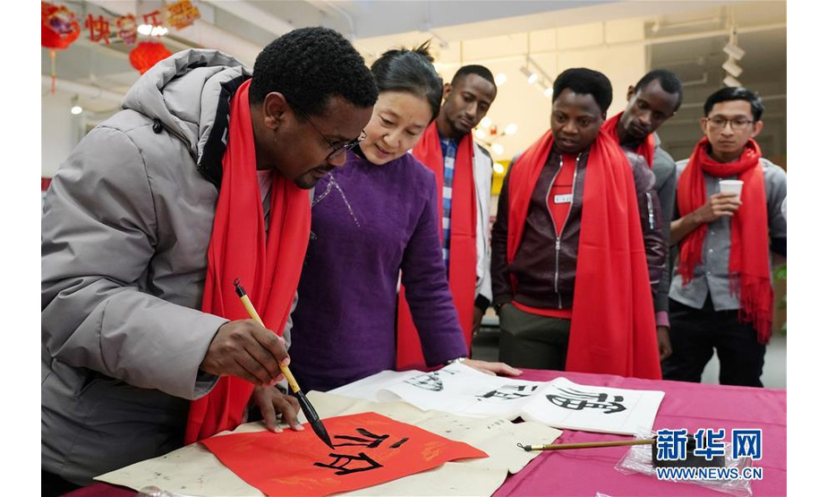 1月20日，来自埃塞俄比亚的留学生孟德（左一）在学写福字。新华社记者 鞠焕宗 摄
