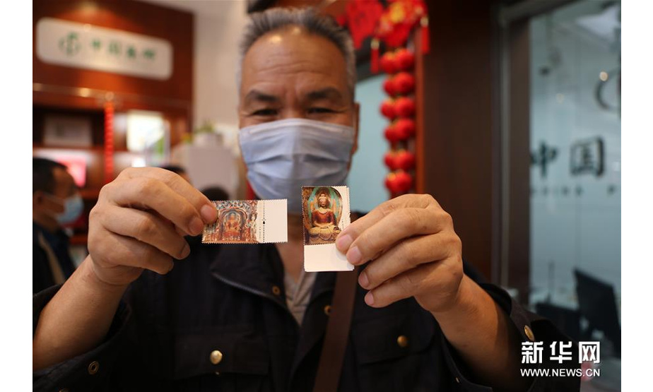 9月26日，在中国集邮专卖店兰州市平凉路店，集邮爱好者展示刚买到的《莫高窟》特种邮票。 新华社记者 耿馨宁 摄