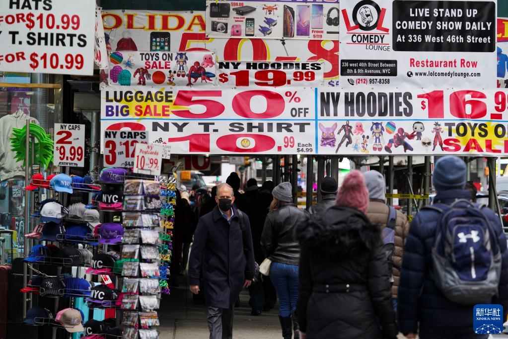 12月7日，在美国纽约时报广场附近，人们从商品促销广告下走过。

　　美国全国商业经济协会6日发布的经济学家调查显示，受需求强劲、薪资上涨、供应链瓶颈等诸多因素影响，美国高通胀将至少持续到2023年。

　　新华社记者 王迎 摄