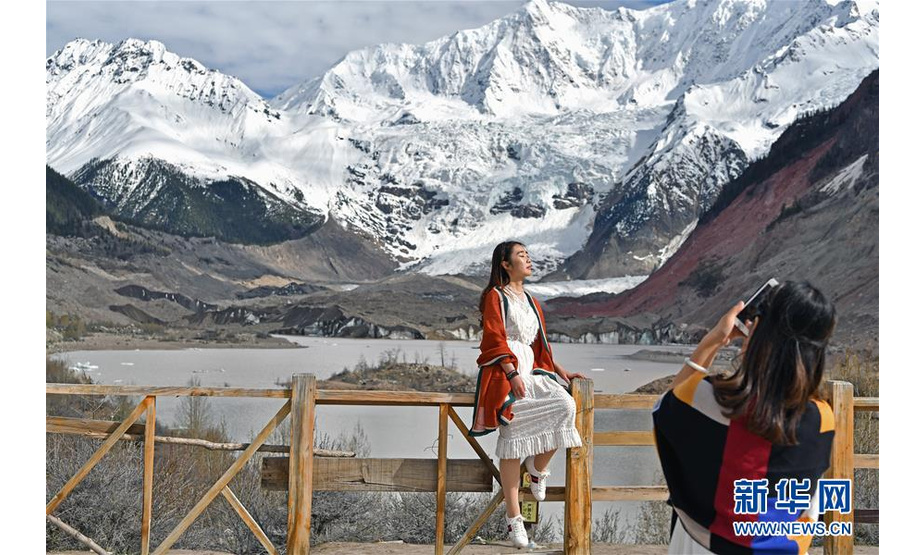 5月16日，游客在米堆冰川前拍照留念。 西藏林芝市波密县玉普乡境内的米堆冰川凭借靠近川藏公路的区位优势，吸引越来越多的游客前来观光游览。波密县因其境内冰川众多被称为“冰川之乡”。 新华社记者 李鑫 摄