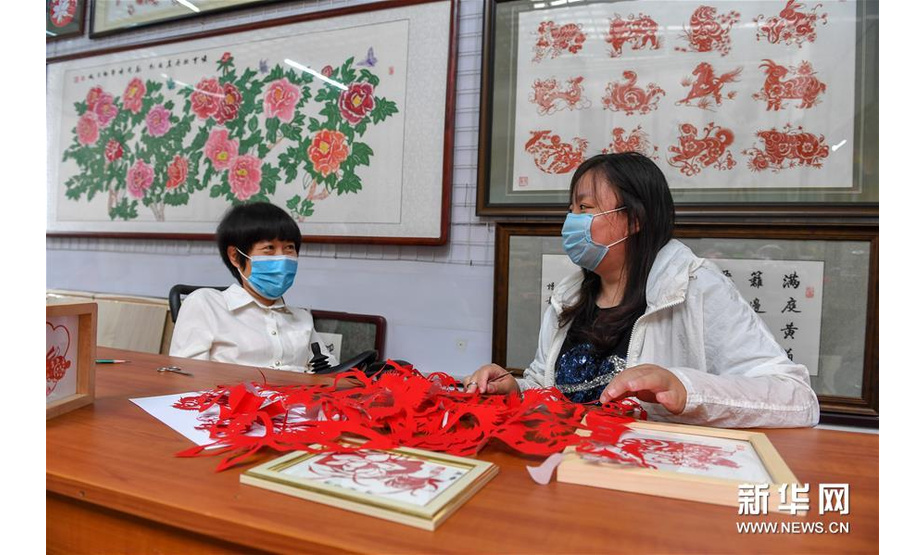 6月29日，华丽（左）指导学员王聪进行剪纸创作。新华社记者 张楠 摄
