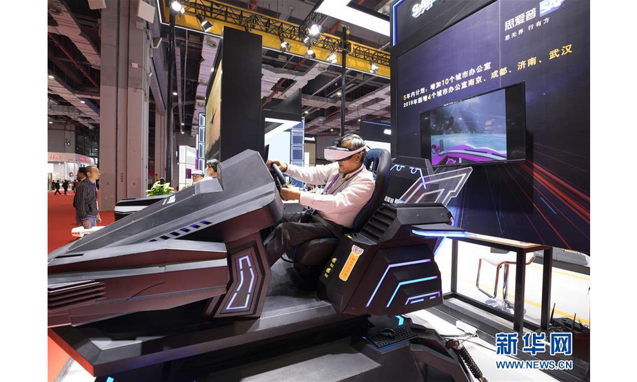 11月5日，一名参观者在第二届进博会科技生活展区体验虚拟现实赛车。 当日，第二届中国国际进口博览会在上海国家会展中心开幕。 新华社记者 金立旺 摄