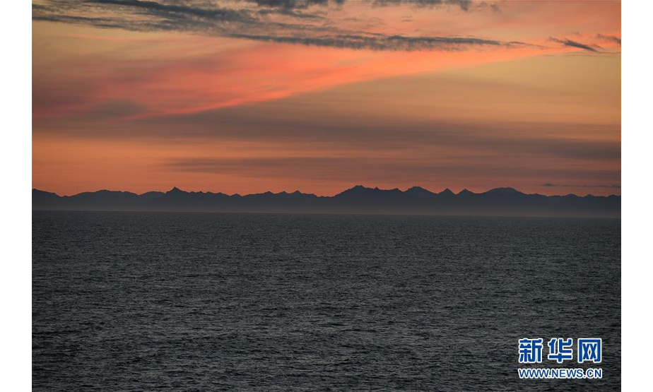 这是8月15日在中远海运“天恩”轮上拍摄的日落，远处为俄罗斯勘察加半岛。新华社记者刘红霞摄