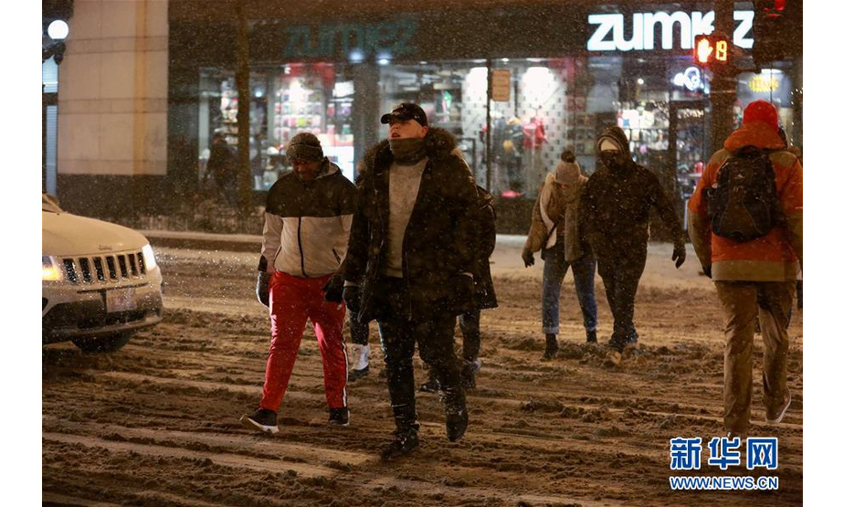 1月17日，在美国芝加哥，行人冒雪出行。 美国芝加哥当日遭暴风雪袭击，地面积雪严重，影响交通和出行。 新华社记者 汪平 摄