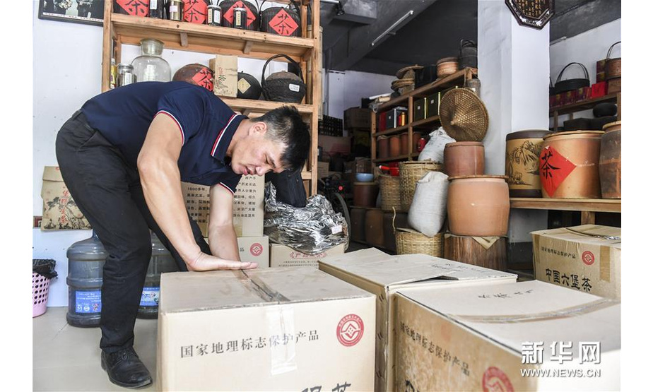 广西梧州市苍梧县一家茶叶销售店负责人将茶叶装箱打包（7月29日摄）。新华社记者 曹祎铭 摄