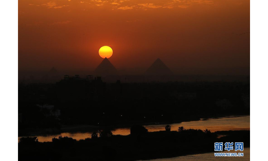这是4月14日从埃及开罗拍摄的吉萨金字塔群日落景色。新华社记者 王东震 摄