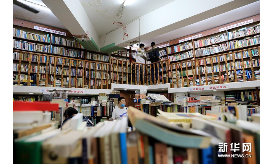 在上海杨浦区政肃路一家菜市场的楼上，有一家专门经营旧书的书店，67平方米的空间外加半环绕的阁楼上，近五万本各类书籍将必要通道以外的所有空间占满，空气中弥漫着旧书特有的气息。书店的主人是来自江苏盐城的张强夫妇。从2002年开店至今，这家只出售旧书的书店靠着爱书人的口耳相传，渐渐有了点名气。张强介绍说，曾经也想给书店起一个有点内涵的名字，但因为开在复旦大学生活区内，又是经营旧书的，大家口中的“复旦旧书店”这个名字就被沿用了下来。复旦旧书店里的书籍，从漫画书到工具书，品类繁杂应有尽有。这里的书籍没有分类，是因为张强想让读者在有限空间里看到更多不同种类的书籍，既为来到这里的读者找书，也为这里的书找读者。 图为7月13日，读者在复旦旧书店内挑选书籍。新华社记者 方喆 摄