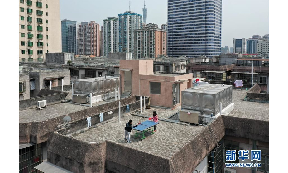 广东广州，两名小朋友在楼顶上打乒乓球（4月10日摄）。 新华社记者 刘大伟 摄
