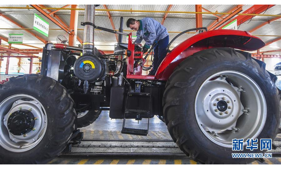 4月3日，河北宏力重工有限公司工人安装大型拖拉机驾驶室底板。