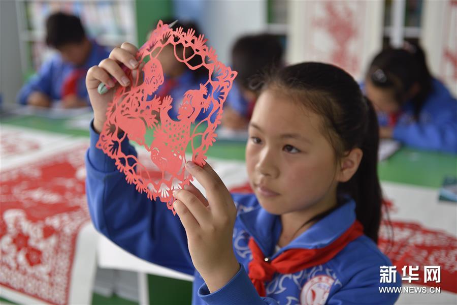 6月13日，民间艺人在大漫港小学辅导学生表演皮影戏。新华社发（刘满仓 摄） 