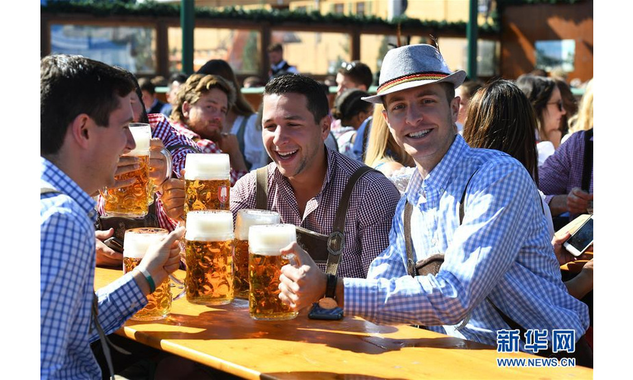 9月21日，人们在德国慕尼黑啤酒节上享用啤酒。 当日，第186届慕尼黑啤酒节在德国南部城市慕尼黑开幕。作为德国最大的民间盛事，本届啤酒节将持续至10月6日。 新华社记者 逯阳 摄