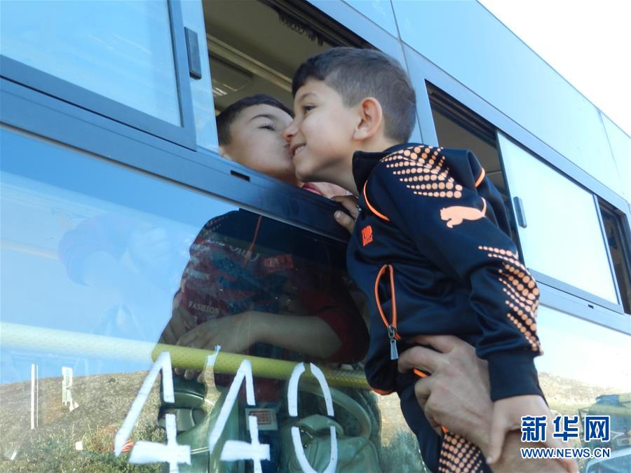 10月10日，在黎巴嫩萨巴阿地区，一名叙利亚男孩透过客车车窗亲吻亲人。 当日，近1000名叙利亚难民从黎巴嫩贝鲁特和的黎波里等城市出发，踏上返乡路。 新华社发（塔希尔摄）