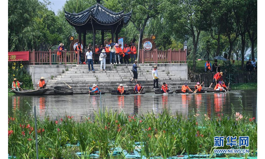 6月5日，村民们在泉益村滨水公园的河道内参加端午划菱桶趣味比赛。 新华社记者 徐昱 摄