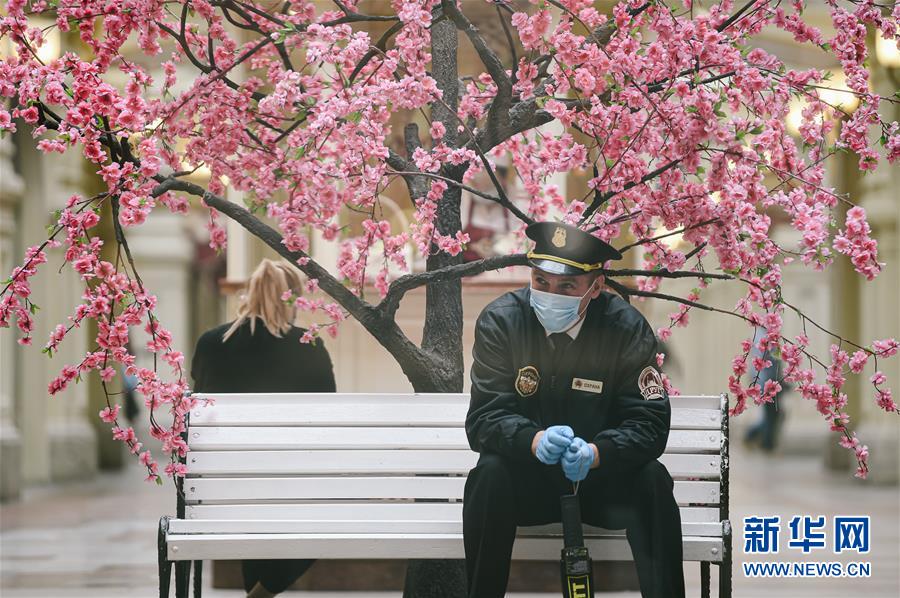 6月1日，在俄罗斯首都莫斯科，一名保安等待商场开门。 当日，位于俄罗斯莫斯科红场的古姆百货商场重新开门营业。莫斯科市政府已决定该市自6月1日起进入放松防疫限制第二阶段，允许市民每周3天可以在不申请通行证情况下外出散步，时段为当天9时至21时，但每天只能出门散步一次，且必须戴口罩和手套。此外，进入第二阶段还允许非食品类商店、洗衣店、其他服务类店铺和周末集市营业。 新华社发（叶甫盖尼·西尼岑摄）