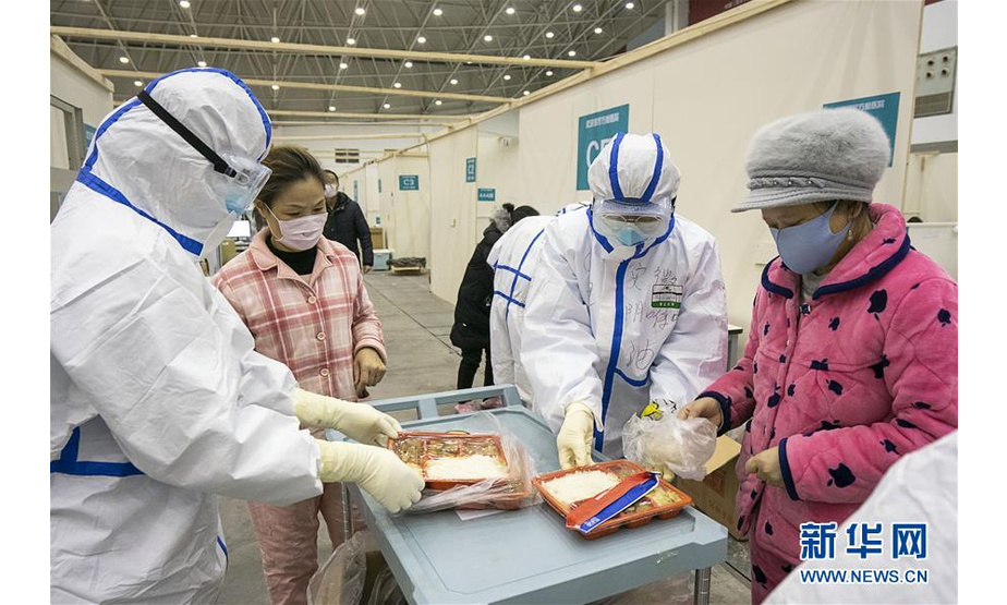 2月10日，在武汉客厅方舱医院，医护人员在分发餐食。 武汉方舱医院从2月5日收治首批患者以来，运行平稳有序，患者在医护人员的精心照顾下调养身体，等待痊愈。 新华社记者 熊琦 摄