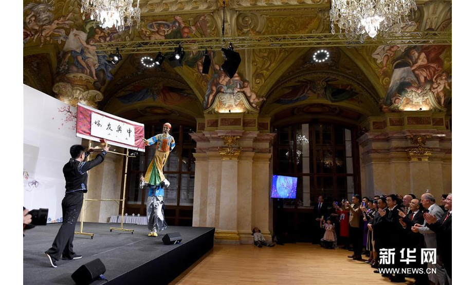 10月9日，在奥地利首都维也纳“文化中国、锦绣四川”四川文化旅游展示会上，人们观看木偶人书法表演。新华社记者 郭晨 摄