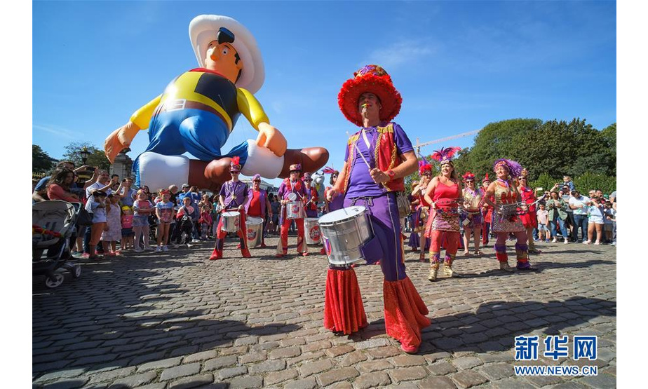 9月15日，人们在比利时首都布鲁塞尔参加卡通气球大巡游。 当日，布鲁塞尔举行第十届布鲁塞尔漫画节卡通气球大巡游，形态各异的卡通气球从街头巷尾穿行而过，吸引大批市民和游客。 新华社记者 张铖 摄