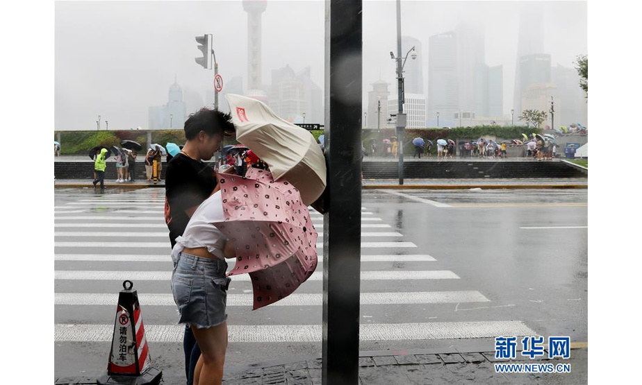 8月17日，游客在雨中等待过马路。新华社记者 方喆 摄