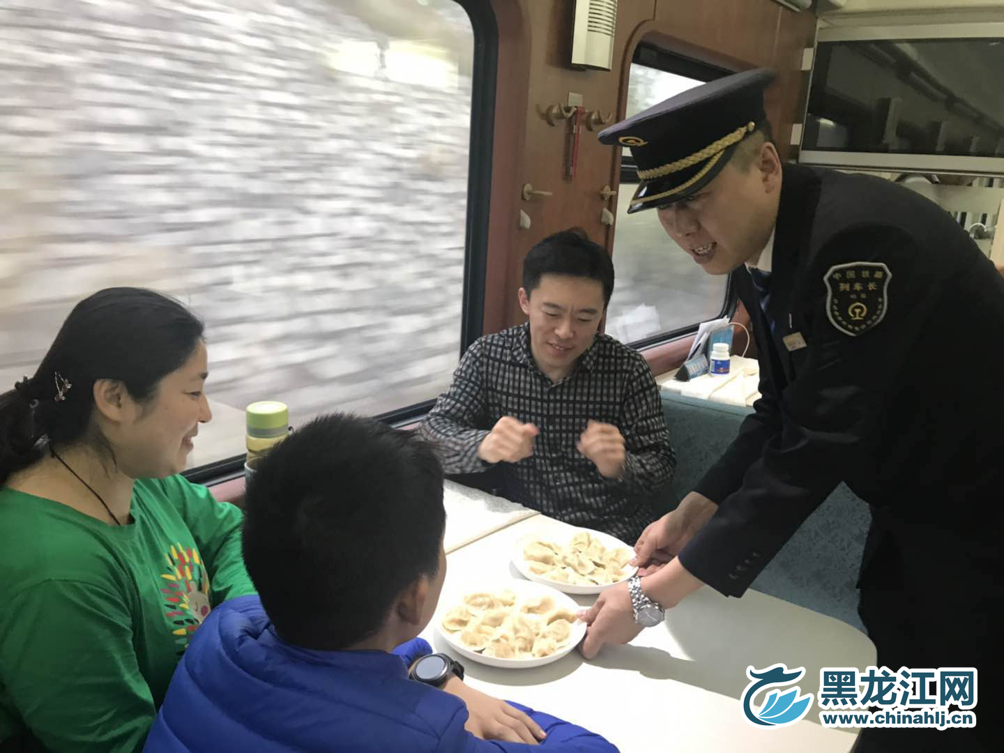 今日19时，距离记者跟随Z114次列车报道已经32个小时了。虽然在过去的30多个小时里，旅客们只能在狭小有限的空间里活动，但是大家并没有感觉到疲惫与乏味。送祝福、唠家常、唱歌、读诗……列车上始终是其乐融融的图景。列车长胡淼也被这喜庆的氛围感动着，亲自为朗诵《读中国》的乘客们端上一盘盘热气腾腾的饺子，让车厢里多了一份年味儿。“过年吃饺子是中国的传统习俗，在春节即将来临之际，我希望我们这份饺子能给大家带去一份家的味道，同时也祝福我们的祖国繁荣昌盛，祝全国人民幸福安康。”胡淼表示。图为列车长将饺子端到乘客面前。  宋菲 摄