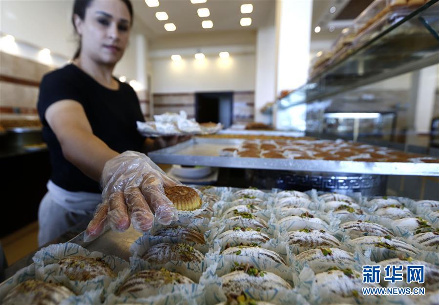 8月25日，在黎巴嫩南部城市赛达，一家甜品店的工作人员装盘售卖“玛阿穆勒”。新华社发（比拉尔·贾维希摄）