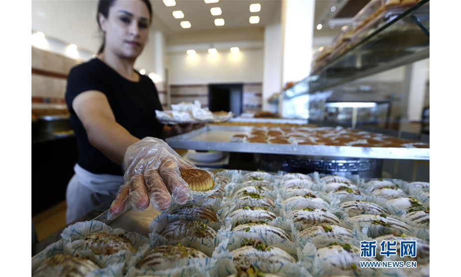 8月25日，在黎巴嫩南部城市赛达，一家甜品店的工作人员装盘售卖“玛阿穆勒”。新华社发（比拉尔·贾维希摄）