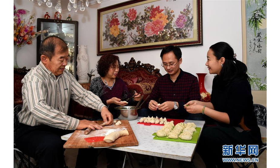 来自内蒙古自治区包头市的徐超，2014年结婚成家后，与丈夫一起在北京工作生活。今年春节，徐超的父母来到北京，与他们共度佳节。这是2月6日，徐超（右一）与家人一起包饺子。