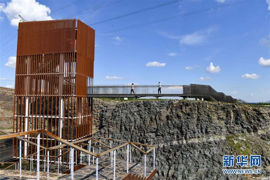 6月30日，游客行走在乌兰浩特市天骏山的栈道上。 天骏山位于内蒙古自治区兴安盟乌兰浩特市郊区，曾因采挖石料而造成山体裸露，植被匮乏，山体上留下了多处深坑。近年来，当地政府加大生态修复力度，为天骏山增添绿色，将荒山改造成旅游景区，吸引游客前往游玩。 新华社发（贝赫 摄）