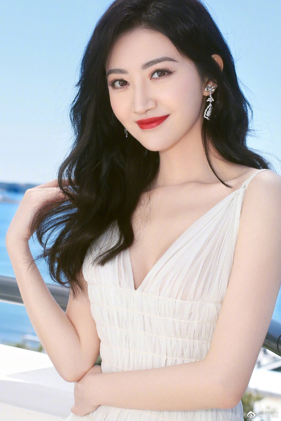 景甜在社交平台上晒出一组戛纳美照，只见她身穿纯白色吊带深V长裙，大秀性感身材。一头长卷发温柔披肩，妆容精致抹红唇气场十足。