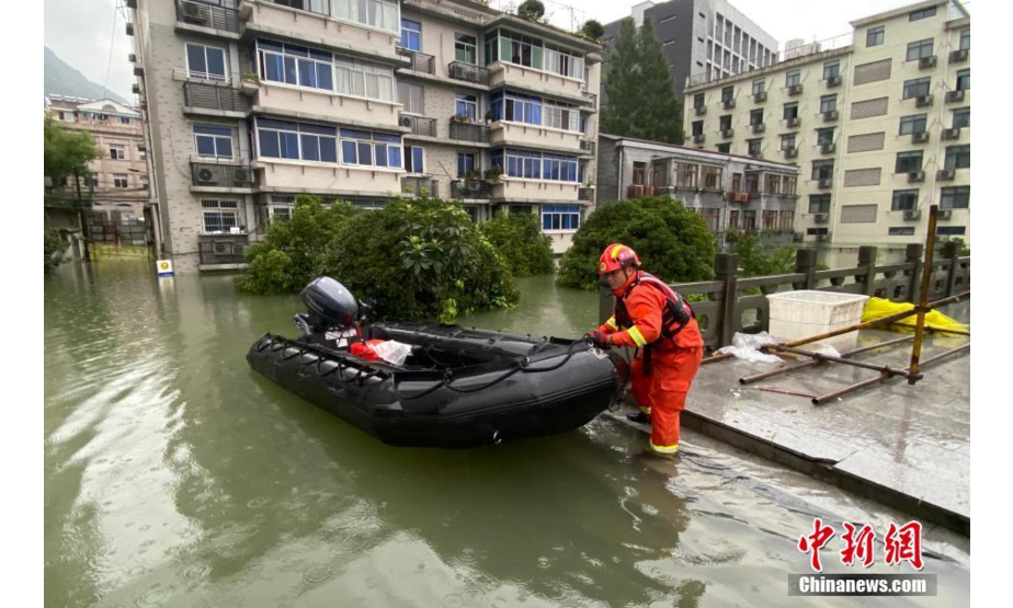一位消防队员在洪水中搬移救生艇。中新社记者 王刚 摄
