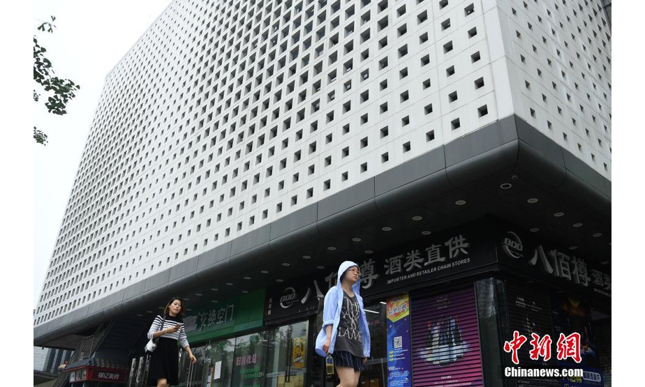 6月25日，重庆街头一建筑外墙十分奇特，墙面上布满了密密麻麻的孔洞，市民戏称这栋建筑为“洞洞楼”。 中新社记者 陈超 摄
